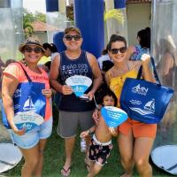 Família Naval posando para a foto com os brindes distribuídos pelo estande AMN