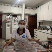 Voluntária com as refeições prontas para entrega