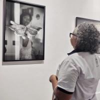 Integrante do Projeto Envelhecer admirando fotografia em exposição